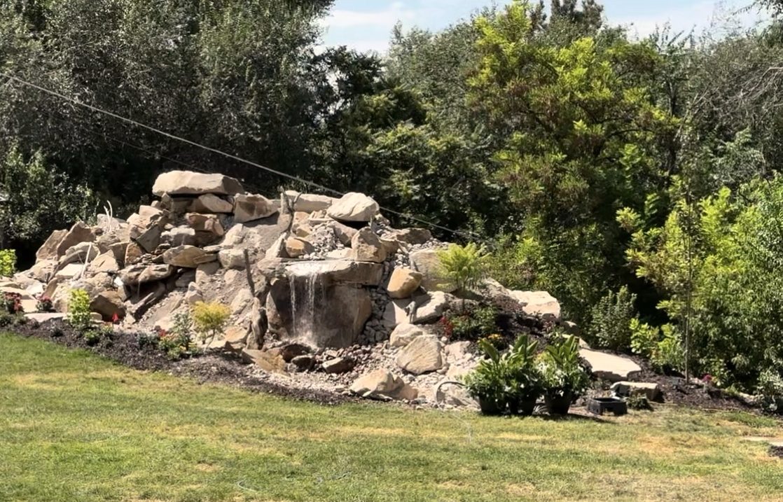 Stone waterfall built into a planted hillside